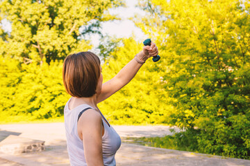 Woman Exercising with Dumbbells in Outdoor Park During Sunny Day - Healthy Lifestyle Concept