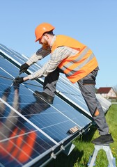 Technician installing solar panels in a solar farm