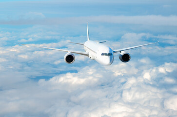 Fototapeta premium White passenger airplane flying in the sky amazing clouds in the background - Travel by air transport