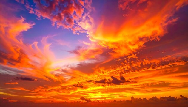 Fiery sunset dramatic orange & yellow clouds burst against a vibrant purple & blue sky