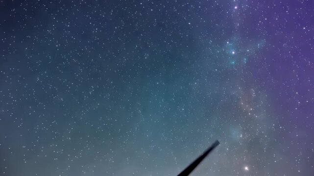 Night sky filled with countless stars and nebulae a glimpse of wind turbine blade in the lower frame
