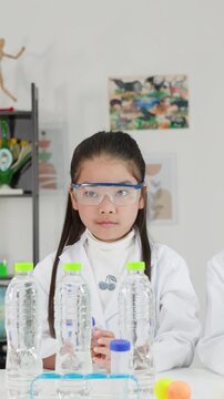 Asian Girl Conducting Bernoulli's Principle Science Experiment in Classroom Laboratory