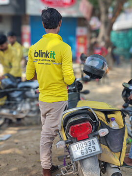 Delivery rider from indian quick commerce hyperlocal delivery startup blinkit standing outside a dark store with package