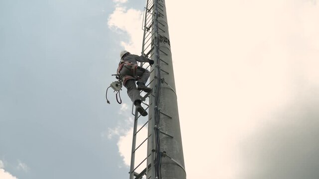 Professional tower climber ascending a communication mast