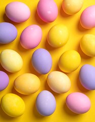 Pastel-colored Easter eggs, pink, yellow, lavender. Eggs randomly fill vibrant yellow background in a close-up