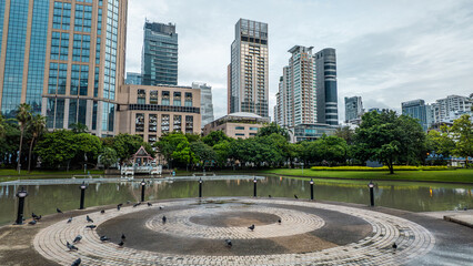 Bangkok Benchasiri park lake and modern skyscrapers, harmony of urban skyline and nature, City pond surrounded by Benjasiri greenery and highrise architecture, balance of metropolis and landscape