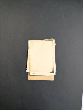 Stack of old photos isolated on dark background. Mock-up blank paper. Vintage old paper collection with place for text of photo frame