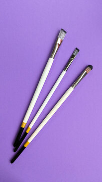White Wooden Synthetic Paintbrush isolated on Violet Background