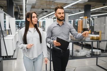 Fototapeta premium Male seller assisting buying woman in a hardware store