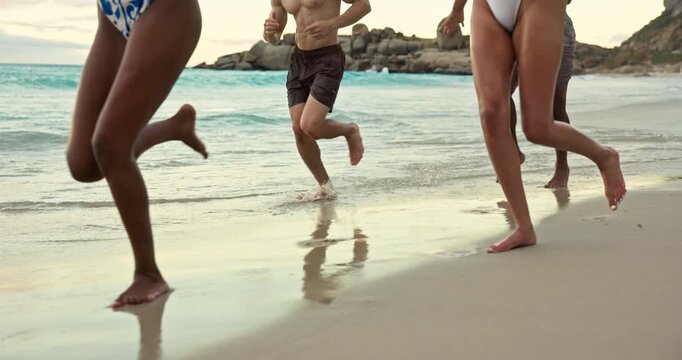 Legs, running and people on beach in waves for summer vacation, holiday and explore for spring break. Happy, weekend and men with women by ocean for freedom, tropical adventure and bonding on trip