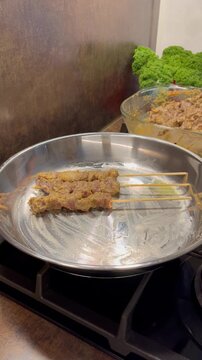 Cooking beef satai with stainless steel pan, delicious Indonesian food