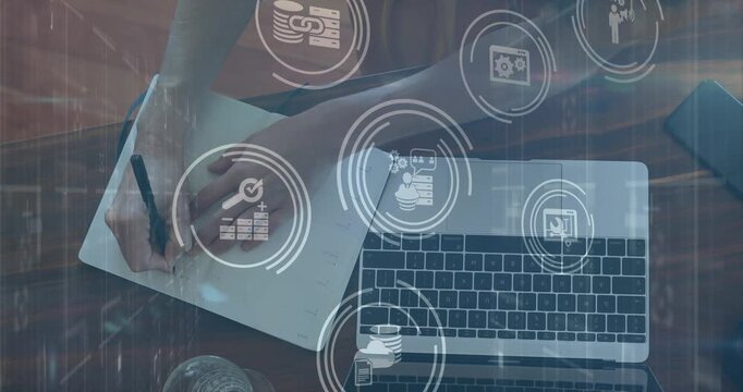 Animation of media icons over caucasian woman taking notes in office