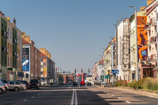 Koszalin, Poland &ndash; September 7, 2024: View along a central city street with residential buildings, traffic lights and cars in northern Poland under clear blue sky.