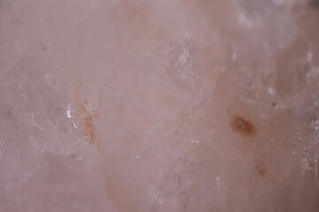 Fototapeta premium Close-up view of a translucent quartz crystal with visible inclusions and natural patterns, showcasing its unique texture and mineral composition in a natural setting