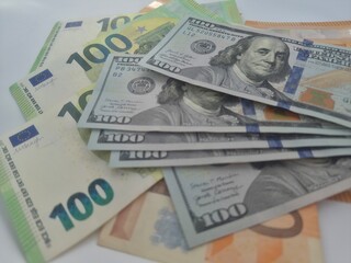 Obraz premium Close-up shot of Euro and US Dollar banknotes scattered on a flat surface, symbolizing global finance and currency exchange.