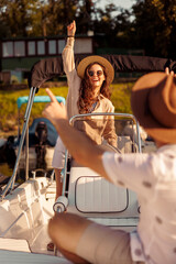 Woman riding a boat while her husband is relaxing on the deck