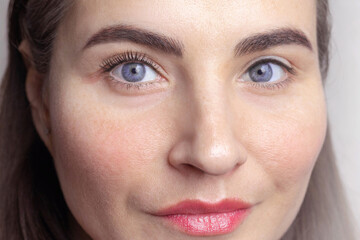 Fototapeta premium Caucasian woman with blue eyes. One eye with twisted eyelashes (with laminated), the second eye is regular, without cosmetic procedures photo beauty