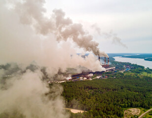 Fototapeta premium A heavy industrial facility a releasing large amounts of pollution into the sky, highlighting the environmental impact.