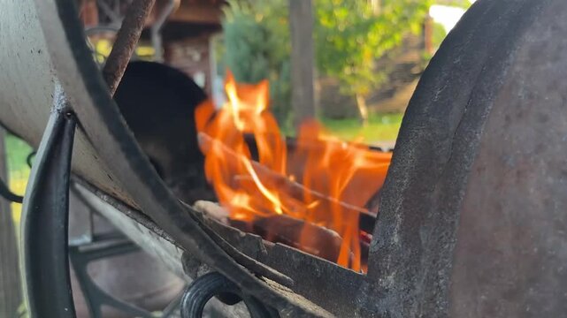 people build a fire in a barbecue grill in their dacha