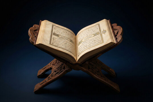 Holy Quran book opened on a carved wooden stand against a dark blue background with dramatic lighting