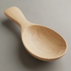 A wooden spoon on a plain gray background with natural light