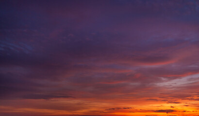 Obraz premium Dramatic Twilight Sky with Vibrant Orange and Purple Sunset Clouds,A breathtaking panoramic view of a dramatic sunset sky, featuring a vibrant gradient of fiery orange, deep red, and moody purple.