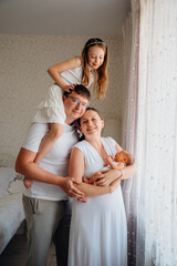 Family poses with newborn and sibling indoors