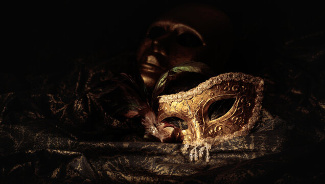 Golden carnival masks on a dark background.