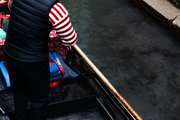 gondolier steering a gondola through the canals of Venice, Italy © Italyteam