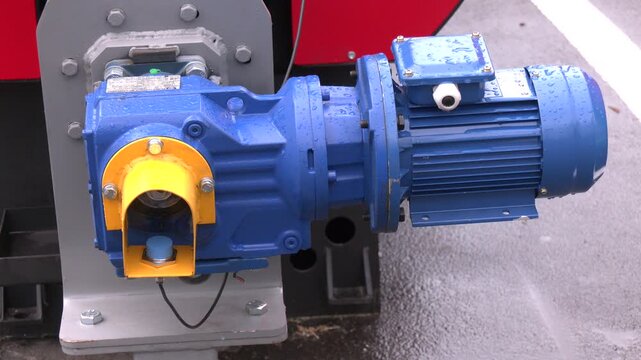 Geared motor on a blue belt conveyor. electric motors in factory setting, showing infrastructure. Industrial three phase electrical motor for water pump circulation on water chiller system.
