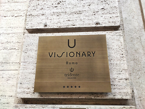 Rome, Italy - February 20, 2026: U Visionary hotel sign mounted on a textured stone wall in Rome, Italy, featuring the Tridente Collection logo and five-star rating
