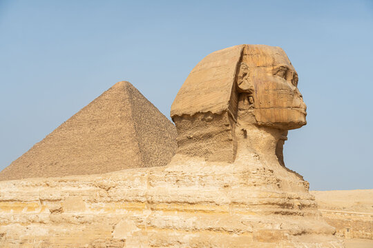The Great Sphinx of Giza with the Great Pyramid of Cheops (Khufu) in the desert landscape, Egypt