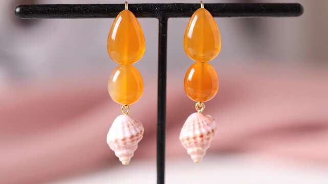Orange Amber Earrings with White Shells Display.