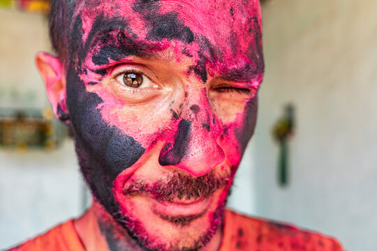 Winking traveler covered in sacred Holi pigment