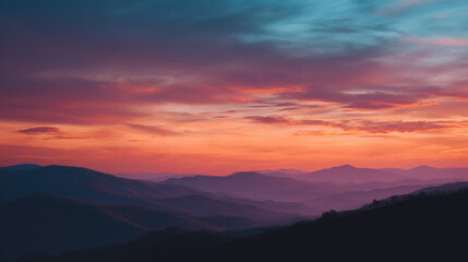Obraz premium Vibrant Sunset Over Misty Mountain Ridges in Layers
