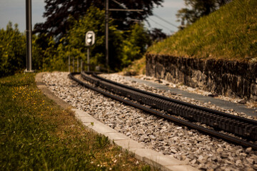 Obraz premium Railway Tracks Through Green Hills Countryside