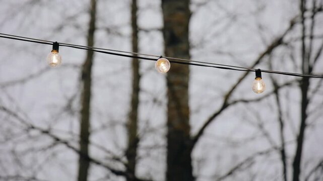 There are light bulbs hanging on a wire in the courtyard, illuminating the surrounding space. Beautiful decorative light