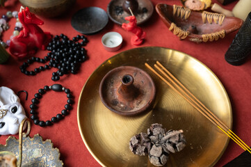 Fototapeta premium Various spiritual and ritualistic items arranged on a red cloth for meditation and practicing magic