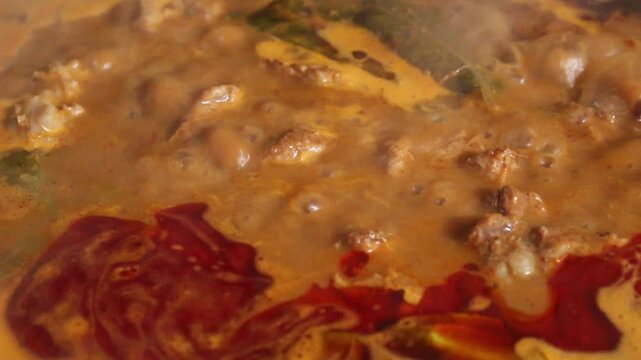 cooking curry in a pan with beef and spices