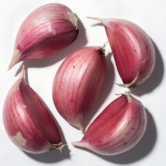 Close up view of several individual purple garlic cloves on a white background, aromatic spice