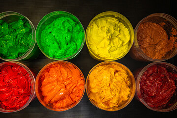 Creative Burst A Top View of Colorful Paint Jars. An artistic composition showcasing a rainbow of...