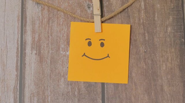 orange paper note with a smiley face hanging from it