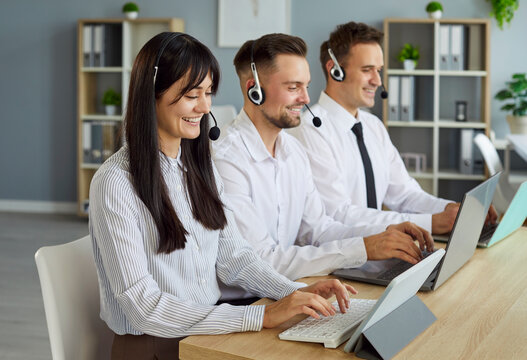 Call center team of professional operators wearing headsets working together in office, providing customer support and service. Support agents showing teamwork, communication and efficiency.