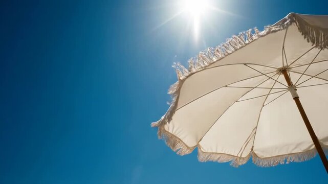 Sunny beach umbrella against bright blue sky, bright daylight