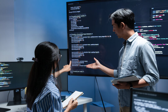 Two Software engineers collaborating in a modern tech office, Male Software Engineer Leader Presenting Code on Screen while discussing code workflow, Ai chat bot project, application Development.