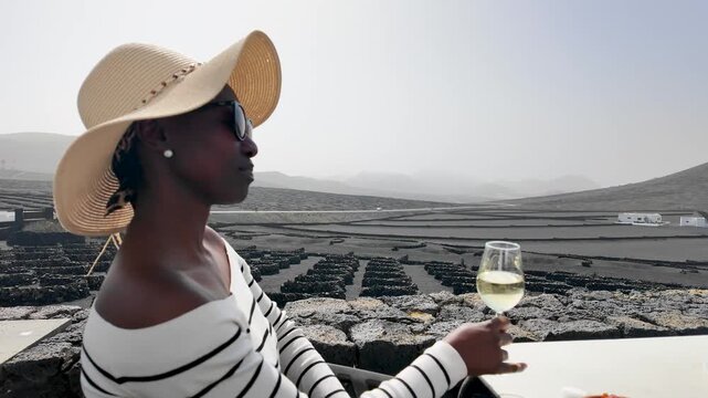 travelling shooting from the volcanic vineyard to a woman drinking a glass of white wine