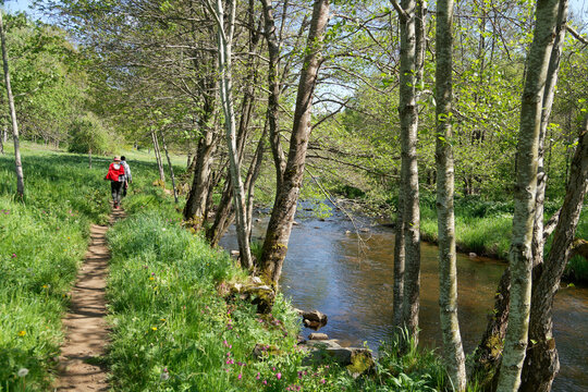Deux marcheurs sur un chemin longeant une rivi&egrave;re
