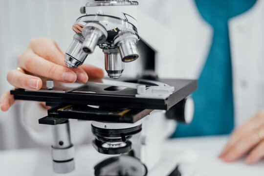 Laboratory specialist examining samples under microscope within biosecurity global health preparedness framework focusing on pathogen detection risk monitoring and resilient medical systems