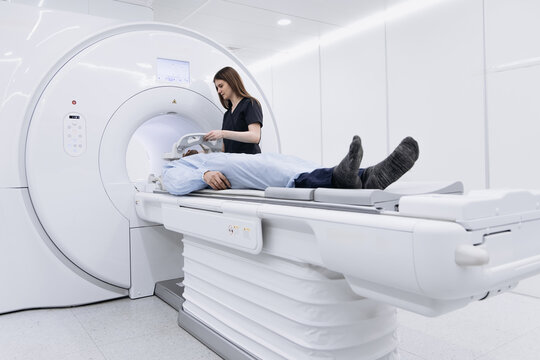 Physician checking patient position and safety before tomography. Medical examination concept
