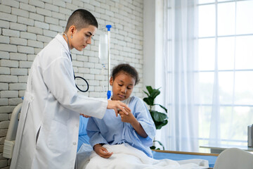 Obraz premium Female doctor gently examining a young girl patient sitting on hospital bed
